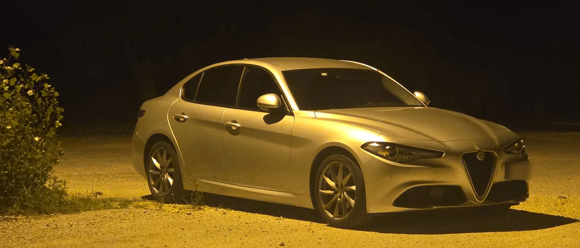 La Giulia di notte, illuminata da un lampione giallo su uno sterrato