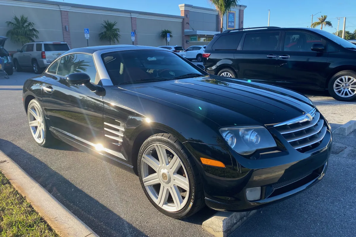 Chrysler Crossfire nera al sole, vista di tre quarti anteriore