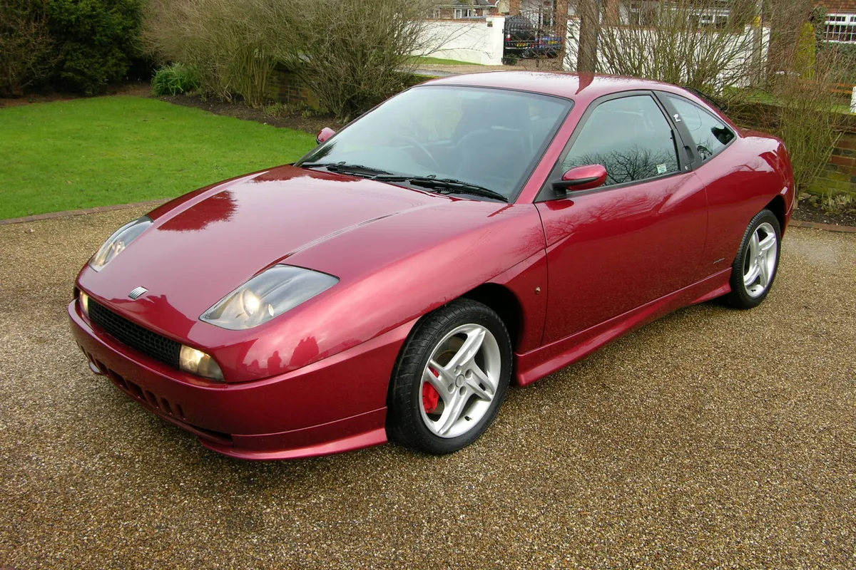 Fiat Coupé rossa su un vialetto di ghiaia