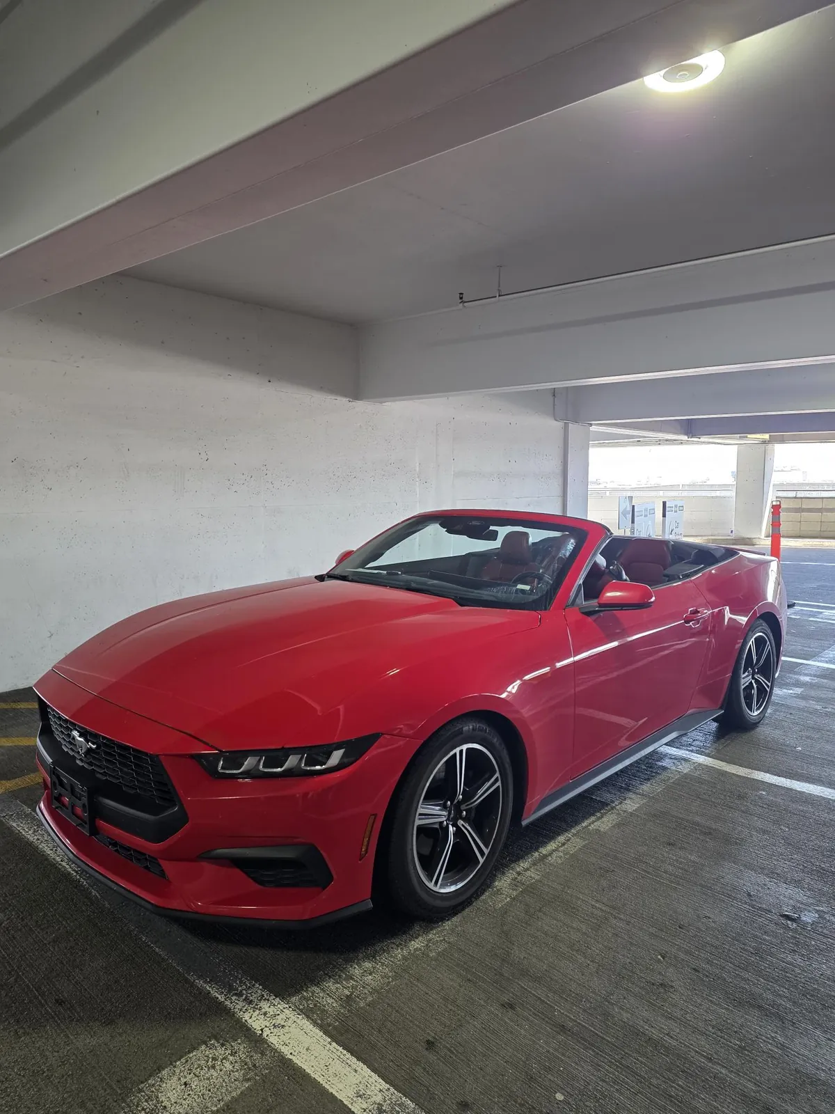 La Mustang aperta in un parcheggio multipiano, vista di tre quarti anteriore